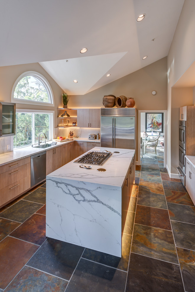This is an example of a mid-sized contemporary l-shaped separate kitchen in San Francisco with flat-panel cabinets, quartz benchtops, stainless steel appliances, porcelain floors, with island, an undermount sink, light wood cabinets, multi-coloured splashback and slate splashback.