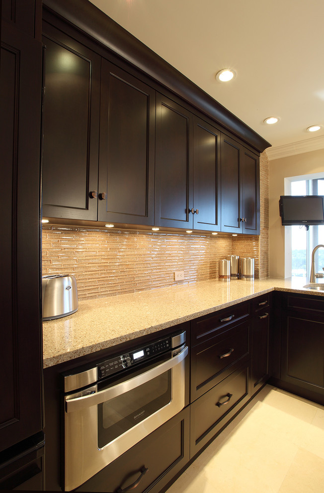 Enclosed kitchen - mid-sized transitional l-shaped porcelain tile and beige floor enclosed kitchen idea in Miami with dark wood cabinets, multicolored backsplash, stainless steel appliances, a drop-in sink, recessed-panel cabinets, terrazzo countertops, glass tile backsplash, no island and beige countertops