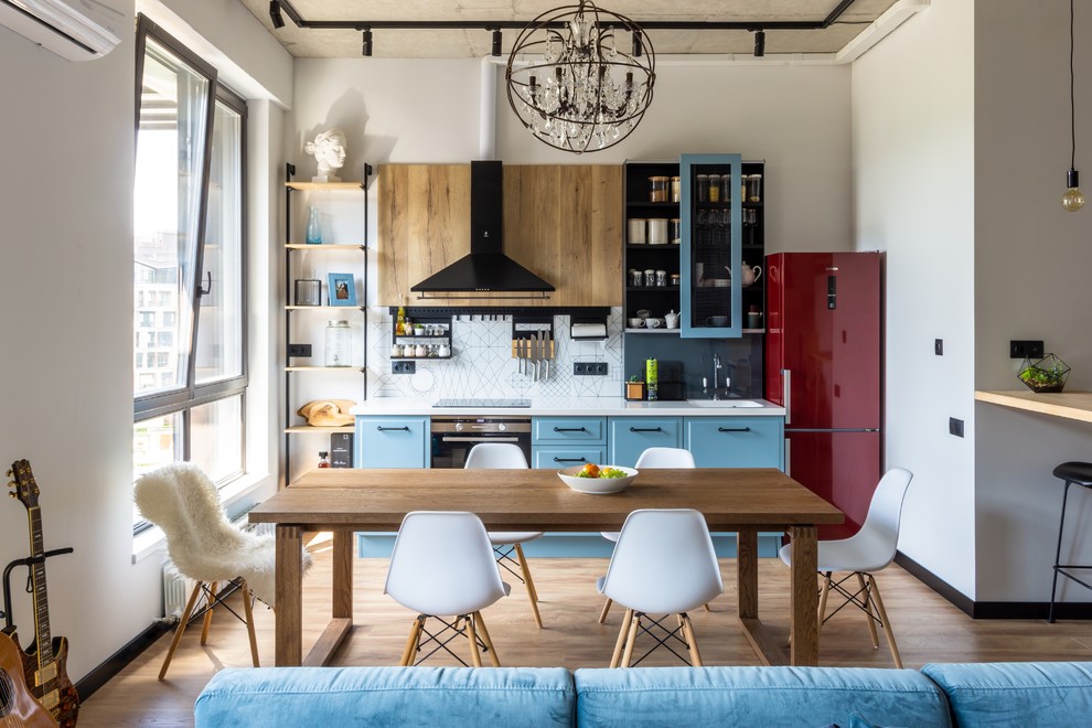 Small single-wall eat-in kitchen in Moscow with an undermount sink, recessed-panel cabinets, solid surface benchtops, white splashback, ceramic splashback, black appliances, laminate floors, no island and white benchtop.