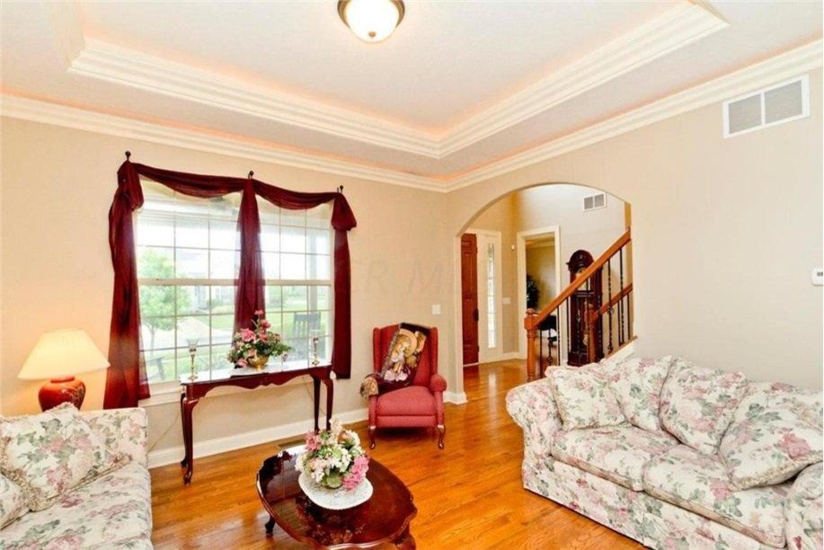 Photo of a large traditional formal enclosed living room in Columbus with beige walls, light hardwood floors and no tv.