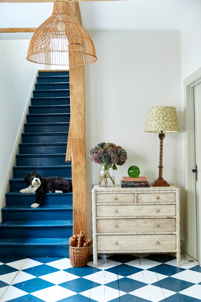 Country painted wood straight staircase in London with painted wood risers and wood railing.