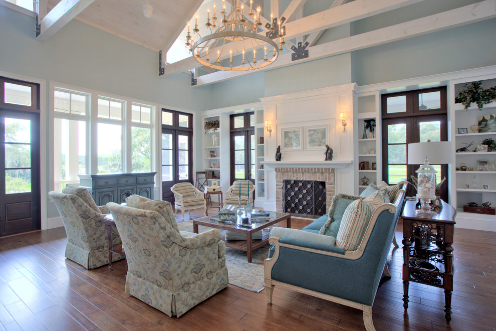 Design ideas for a mid-sized traditional formal open concept living room in Charleston with blue walls, medium hardwood floors, a standard fireplace, a brick fireplace surround and no tv.