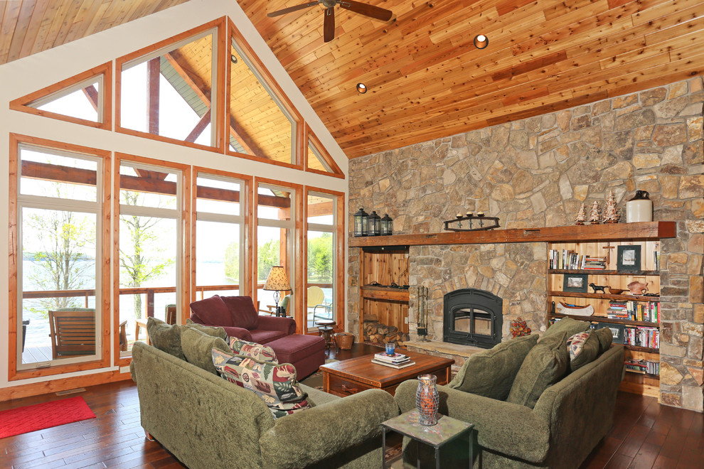 Inspiration for a mid-sized country open concept living room in Other with dark hardwood floors, a standard fireplace, a stone fireplace surround, no tv and brown floor.