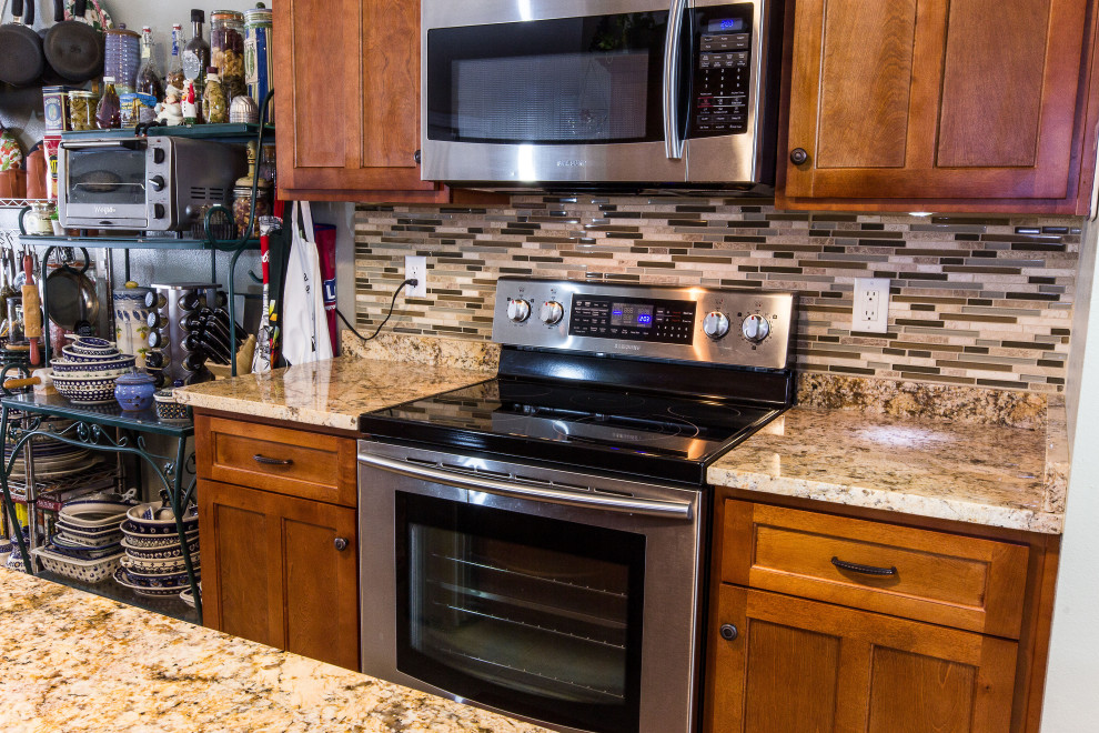 Inspiration for a mid-sized galley cement tile floor and beige floor eat-in kitchen remodel with an undermount sink, shaker cabinets, medium tone wood cabinets, granite countertops, multicolored backsplash, glass sheet backsplash, stainless steel appliances, an island and beige countertops