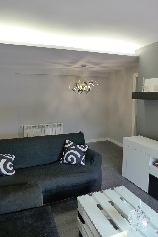 Ejemplo de salón cerrado minimalista de tamaño medio con paredes grises, suelo laminado y suelo gris