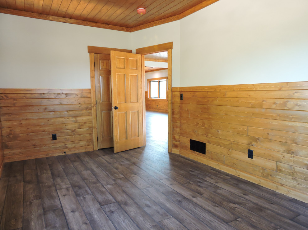 Ejemplo de despacho rústico de tamaño medio con paredes beige, suelo vinílico, suelo marrón, madera y madera