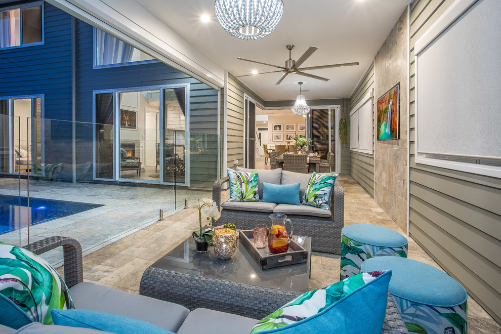 Design ideas for a mid-sized traditional backyard patio in Brisbane with natural stone pavers and a roof extension.