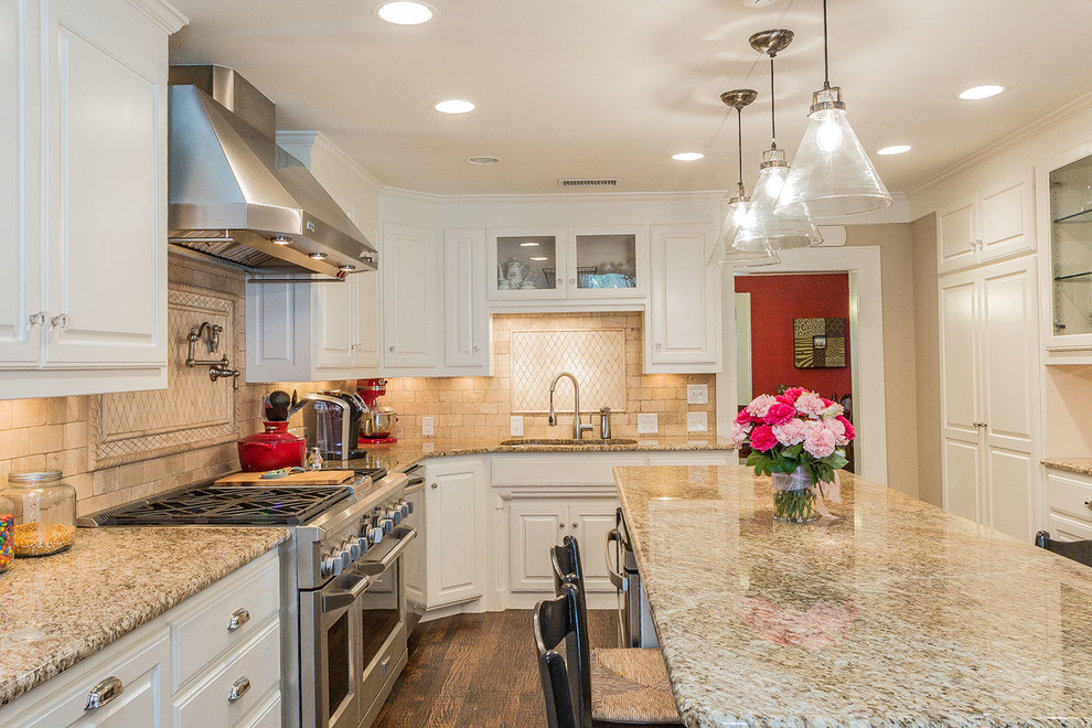 L-shaped kitchen in Dallas with a double-bowl sink, raised-panel cabinets, white cabinets, granite benchtops, beige splashback, stone tile splashback, stainless steel appliances, dark hardwood floors and with island.