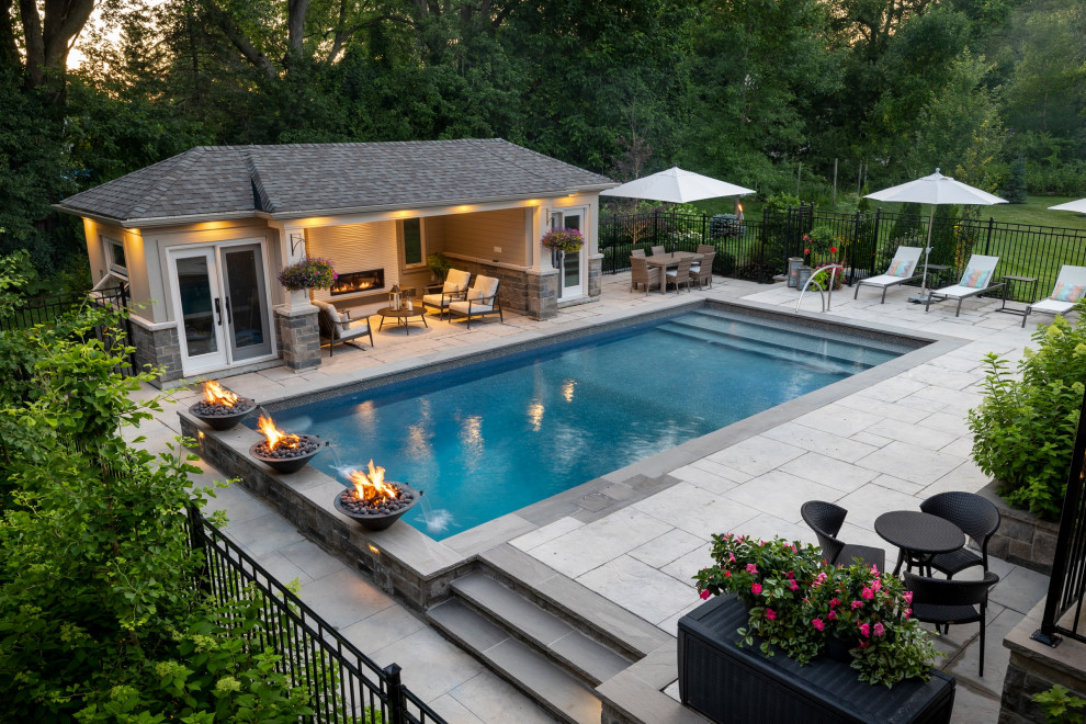 Mid-sized transitional backyard stamped concrete and rectangular pool landscaping photo in Toronto