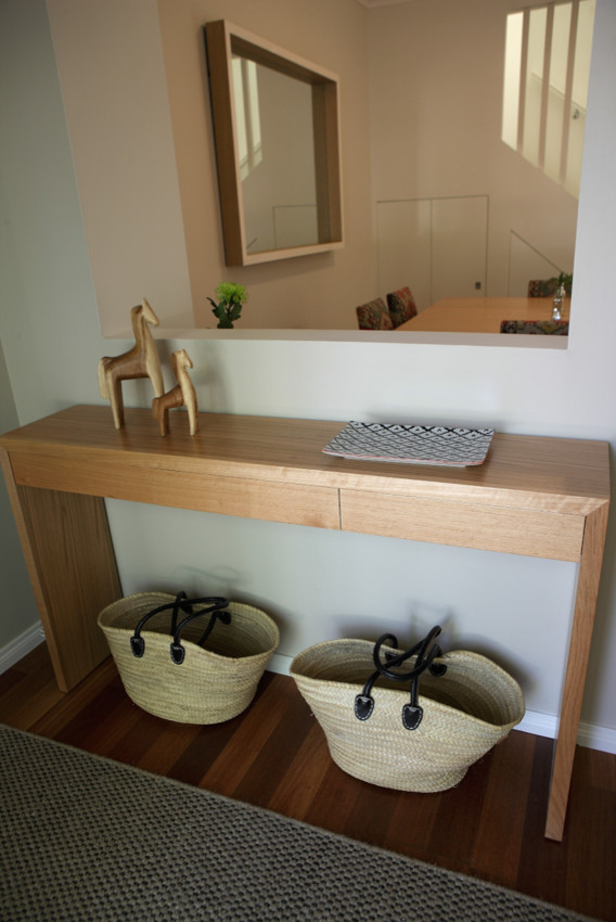 This is an example of a small contemporary foyer in Melbourne with beige walls and medium hardwood floors.