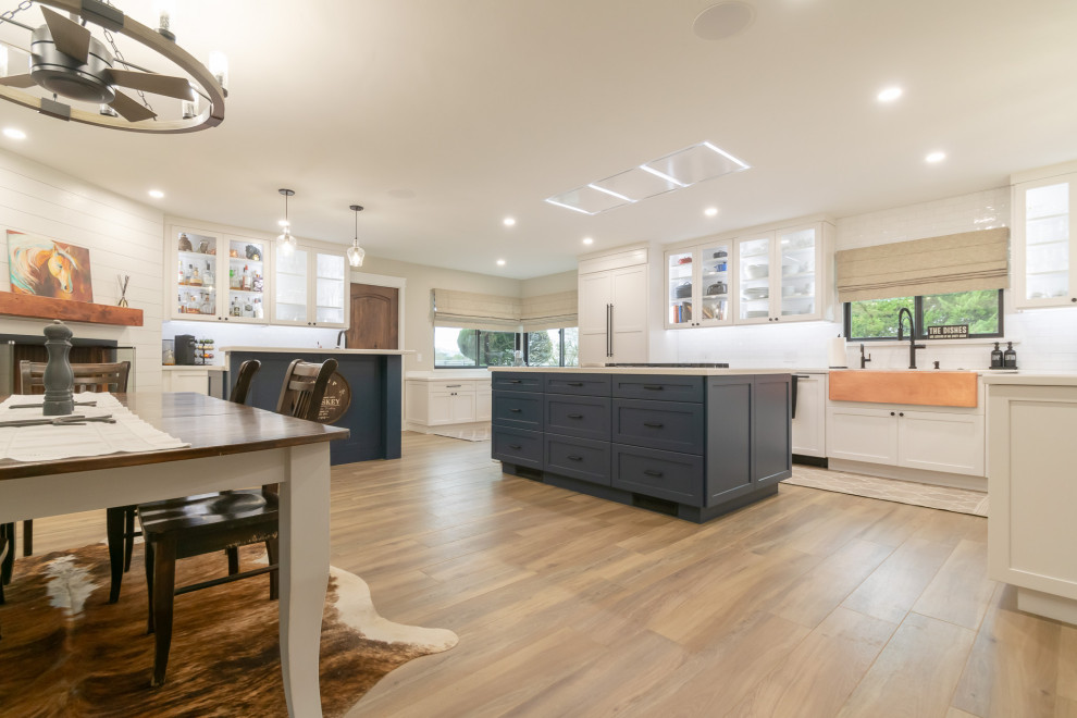 Example of a huge mountain style l-shaped open concept kitchen design in San Francisco with an undermount sink, shaker cabinets, white backsplash, ceramic backsplash, stainless steel appliances and an island