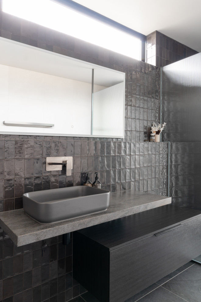Idéer för ett stort modernt svart en-suite badrum, med släta luckor, svarta skåp, svart kakel, keramikplattor, klinkergolv i keramik, bänkskiva i akrylsten och grått golv