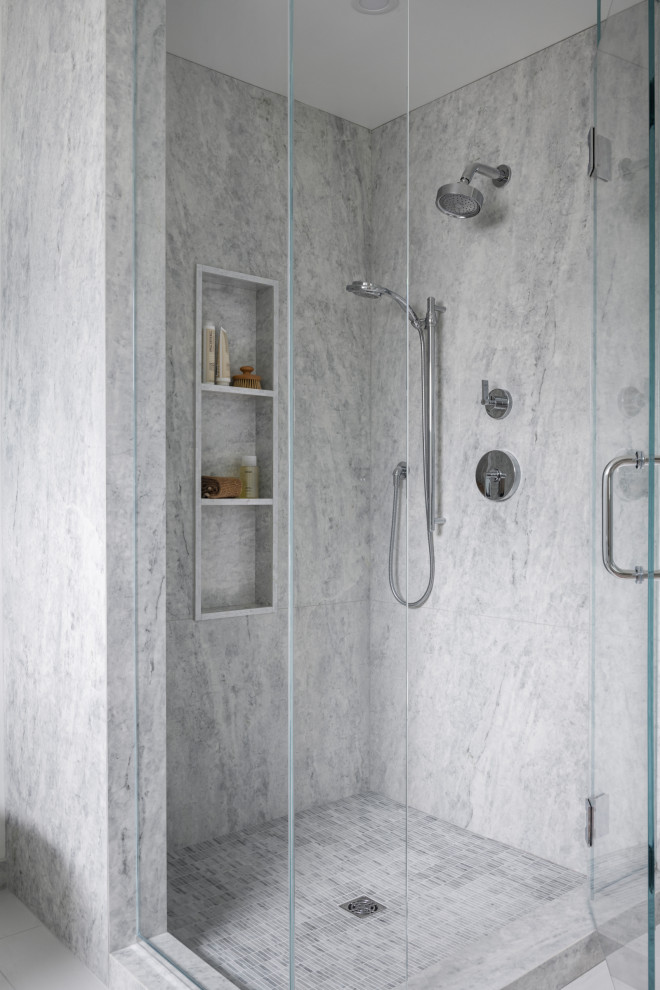 Идея дизайна: главная ванная комната среднего размера в стиле модернизм с плоскими фасадами, светлыми деревянными фасадами, отдельно стоящей ванной, угловым душем, унитазом-моноблоком, белой плиткой, мраморной плиткой, белыми стенами, полом из керамогранита, врезной раковиной, мраморной столешницей, белым полом, душем с распашными дверями, серой столешницей, нишей, тумбой под две раковины и встроенной тумбой