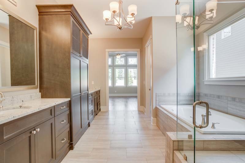 This is an example of a large traditional master bathroom in Atlanta with an undermount sink, shaker cabinets, dark wood cabinets, granite benchtops, a curbless shower, gray tile, ceramic tile, beige walls and ceramic floors.