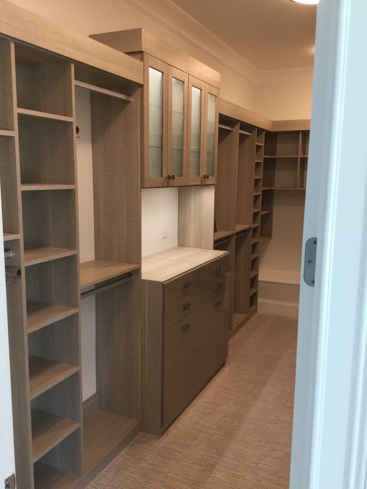 Photo of a large modern men's walk-in wardrobe in Cincinnati with glass-front cabinets, grey cabinets, carpet and grey floor.