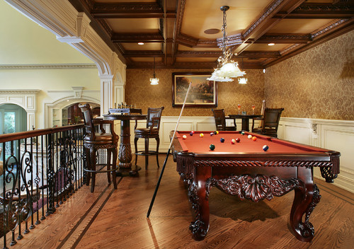 Luxury game room featuring a billiard table, pendant lighting and two pub table sets with bar stools