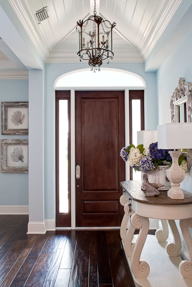 Inspiration for a tropical brown floor entryway remodel in Miami with blue walls
