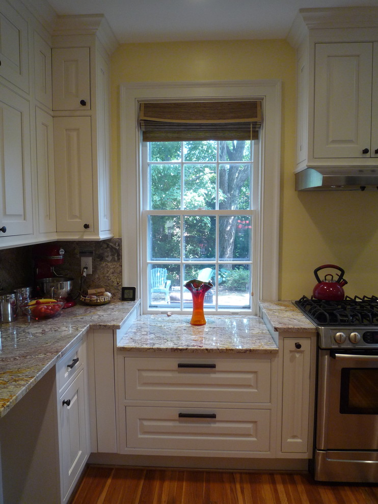 Mid-sized transitional medium tone wood floor enclosed kitchen photo with an undermount sink, raised-panel cabinets, white cabinets, granite countertops, multicolored backsplash, stone slab backsplash, stainless steel appliances and no island