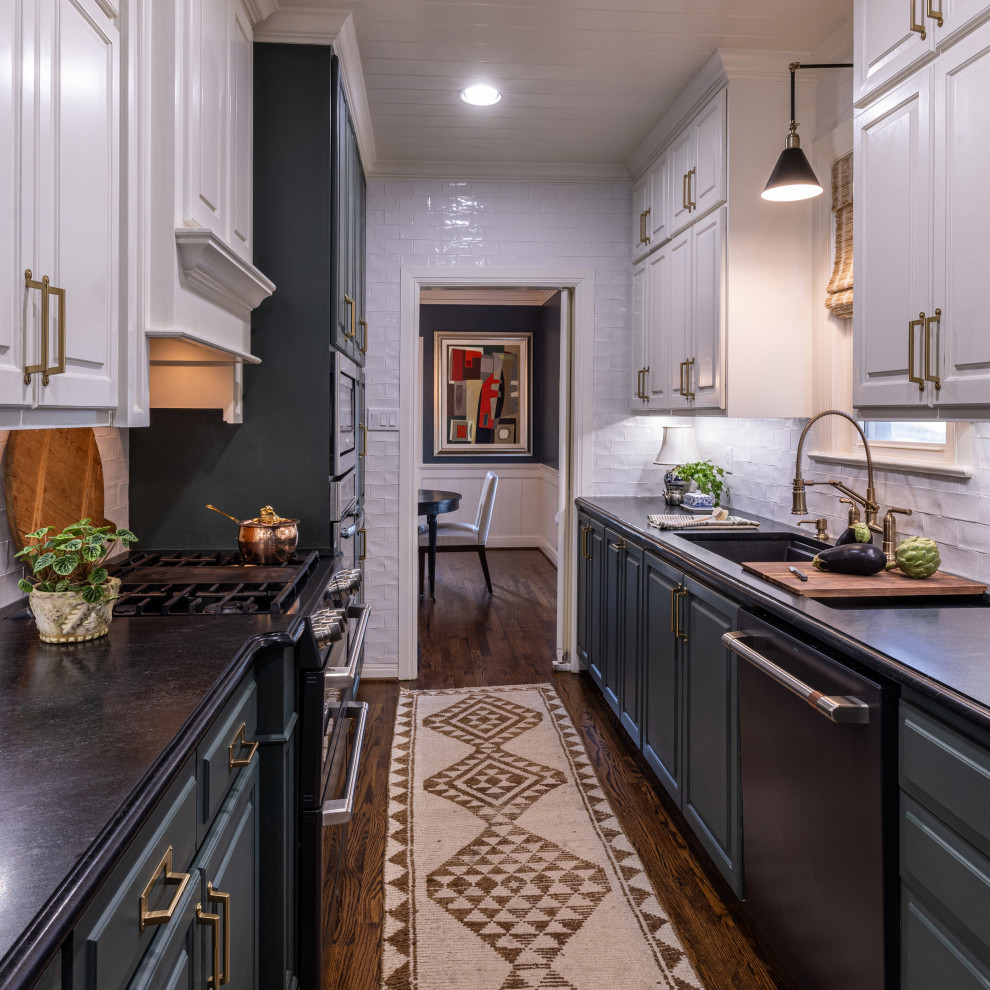 Mid-sized contemporary galley eat-in kitchen in Dallas with raised-panel cabinets, green cabinets, granite benchtops, white splashback, ceramic splashback, black appliances, medium hardwood floors, no island, brown floor, black benchtop, timber and a double-bowl sink.