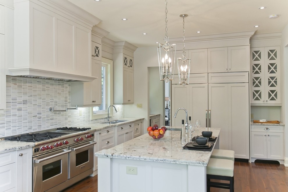 Eat-in kitchen - large transitional galley medium tone wood floor and brown floor eat-in kitchen idea in Toronto with an undermount sink, shaker cabinets, white cabinets, granite countertops, white backsplash, glass tile backsplash, stainless steel appliances and an island