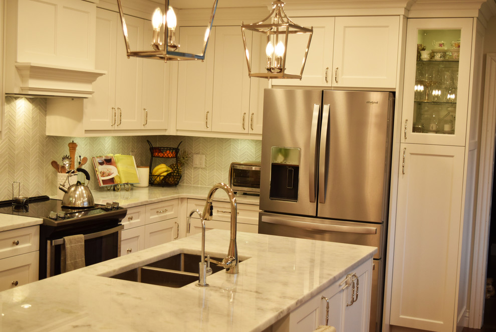 Example of a transitional kitchen design with an undermount sink, stainless steel appliances, an island and white countertops