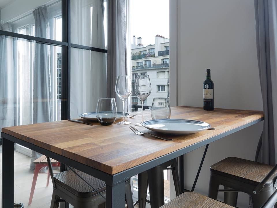 Idées déco pour une petite salle à manger ouverte sur le salon industrielle avec un mur gris et parquet clair.