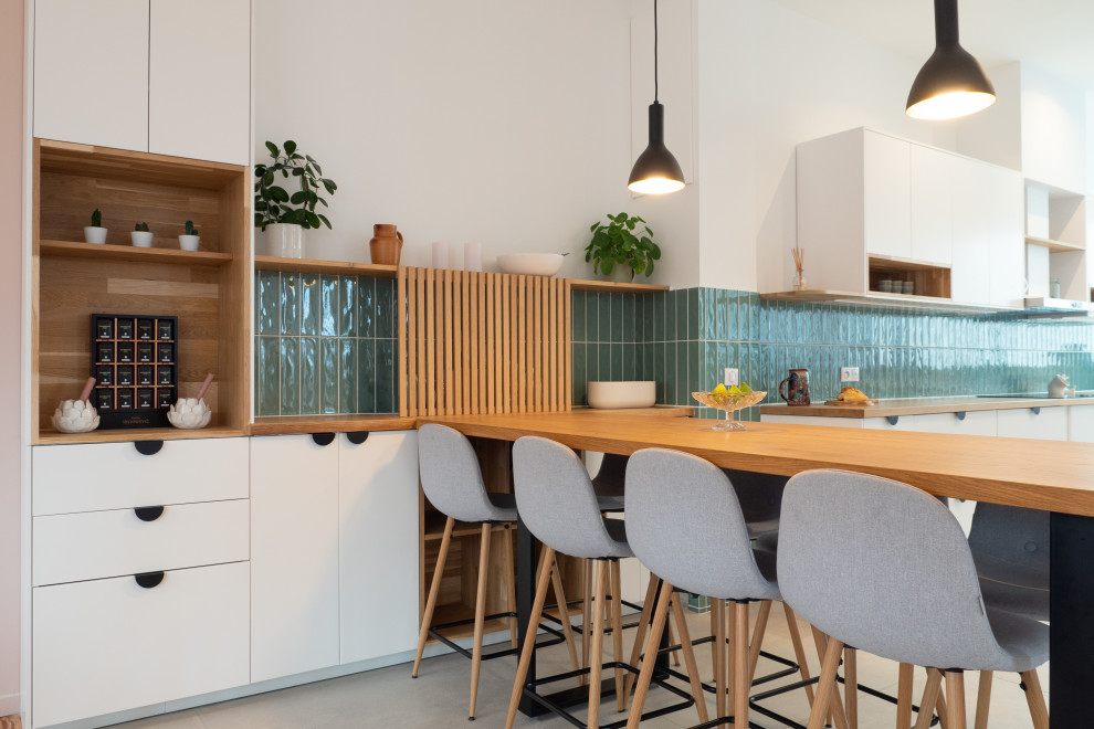 Idée de décoration pour une grande cuisine ouverte blanche et bois nordique avec un plan de travail en bois, une crédence verte, une crédence en céramique et un sol beige.