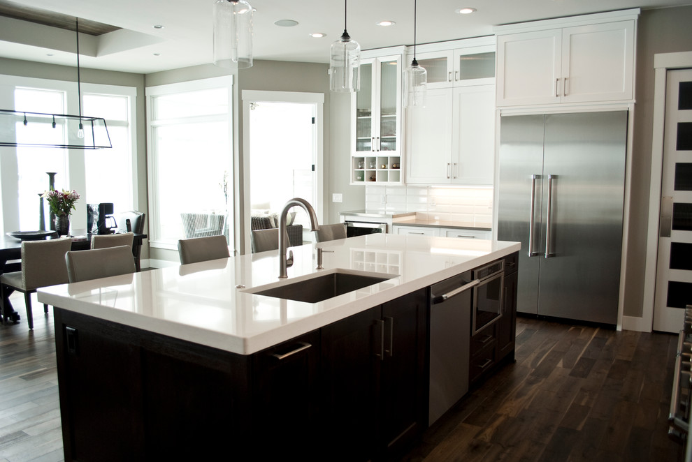 Kitchen - transitional kitchen idea with recessed-panel cabinets, white cabinets, quartz countertops, white backsplash, stainless steel appliances and an island