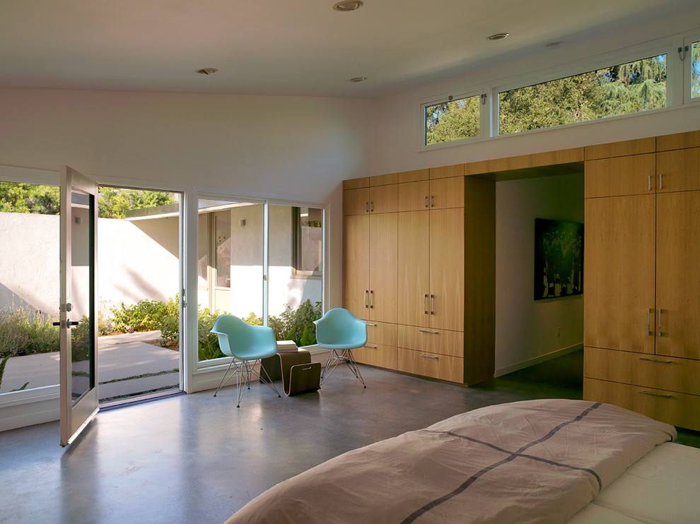 Inspiration for a mid-sized midcentury master bedroom in Los Angeles with concrete floors, white walls and no fireplace.