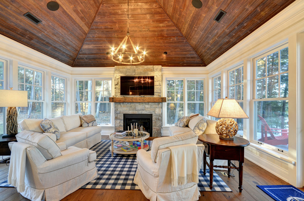Mid-sized country living room in Toronto with white walls, medium hardwood floors, a standard fireplace, a stone fireplace surround and a wall-mounted tv.