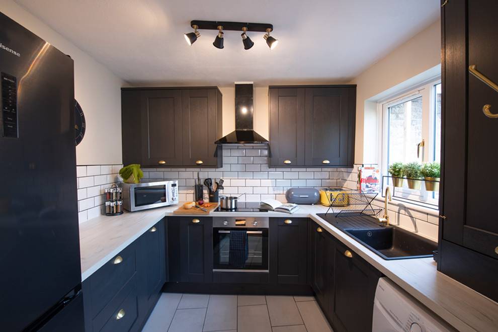 Small contemporary u-shaped separate kitchen in Oxfordshire with white splashback, subway tile splashback and white benchtop.