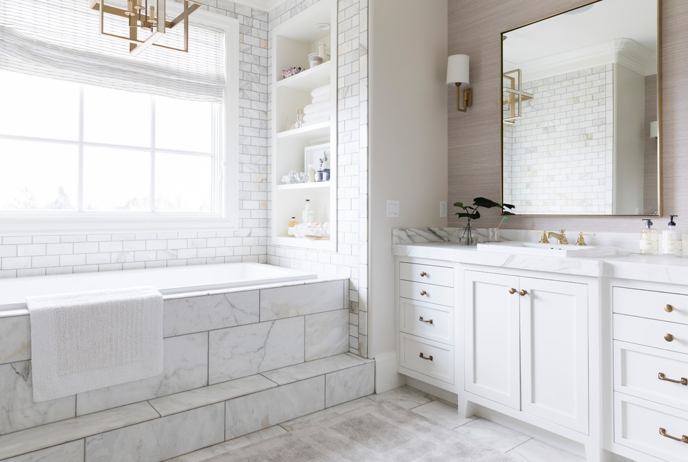 Photo of a transitional bathroom in Salt Lake City with shaker cabinets, white cabinets, a drop-in tub, white tile, subway tile, a drop-in sink, white floor and white benchtops.