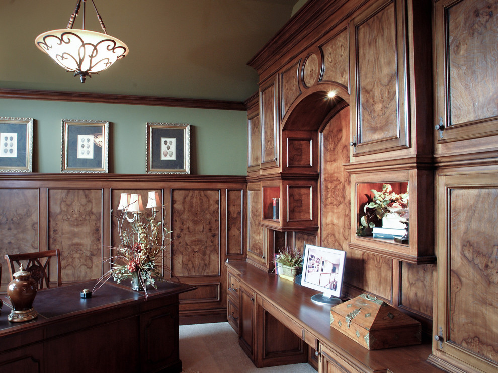 Ejemplo de despacho clásico con paredes verdes, moqueta y escritorio empotrado