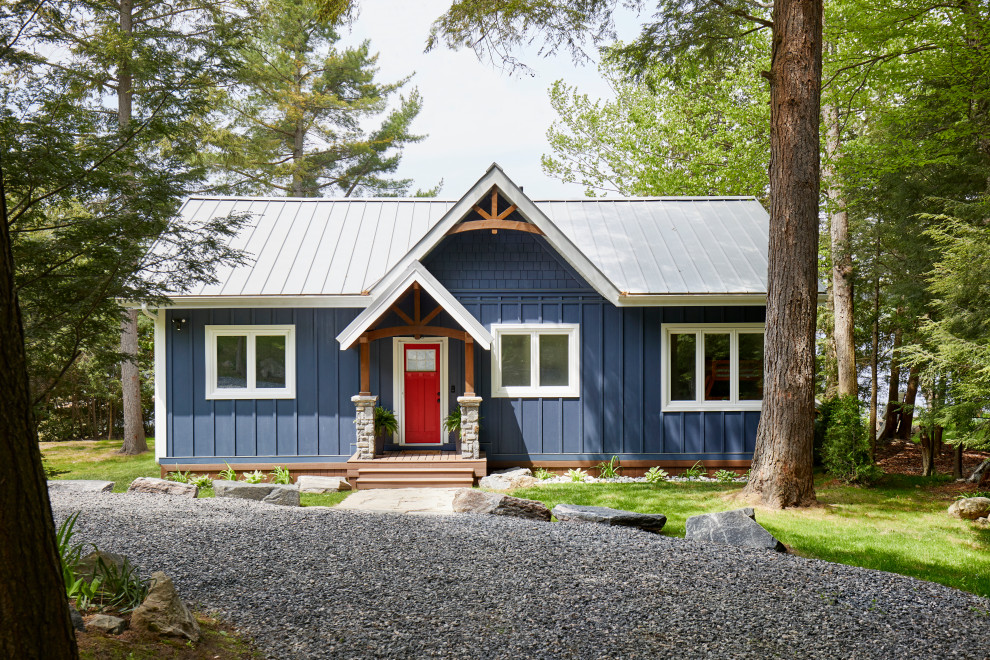Small country one-storey blue house exterior in Toronto with concrete fiberboard siding, a gable roof, a metal roof, a grey roof and board and batten siding.