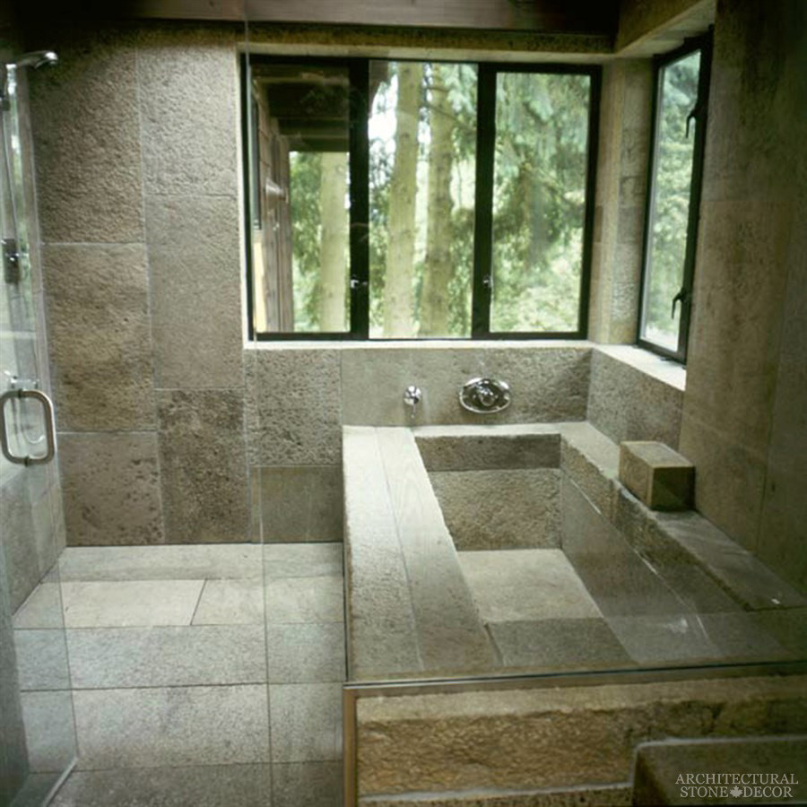 This is an example of a mid-sized mediterranean master bathroom in Toronto with a corner tub, an open shower, gray tile, limestone, limestone floors, a trough sink and limestone benchtops.
