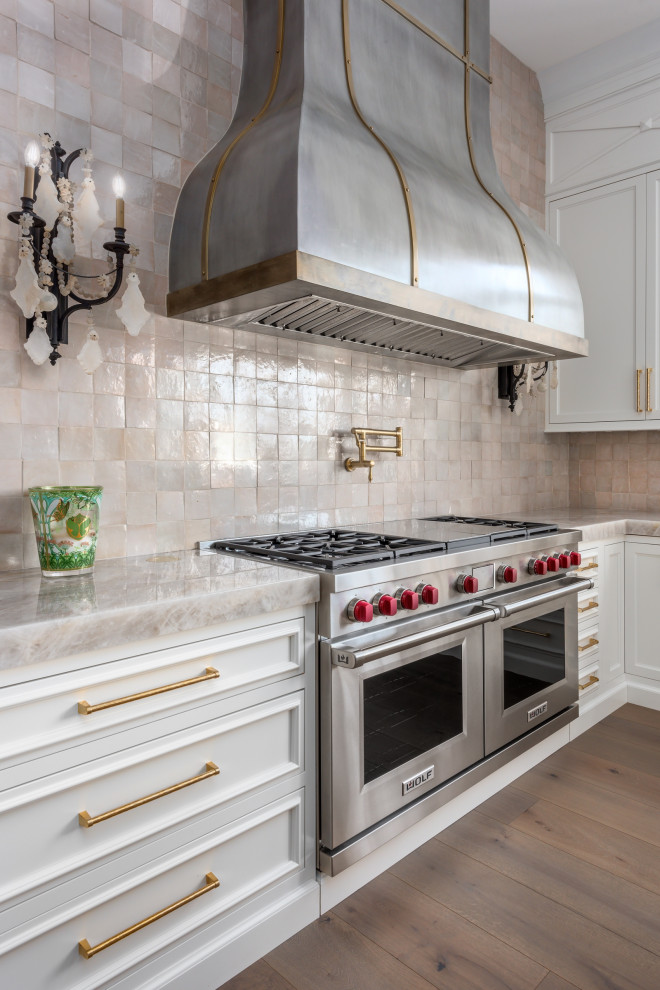 Exempel på ett mycket stort klassiskt kök, med luckor med infälld panel, vita skåp, bänkskiva i kvartsit, integrerade vitvaror, mellanmörkt trägolv, en köksö och brunt golv