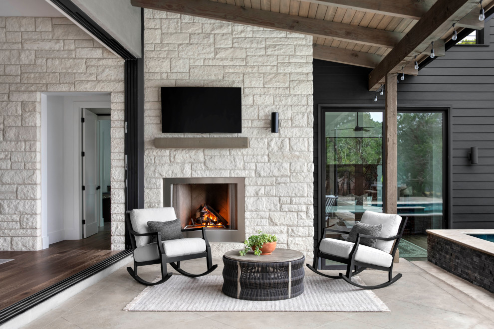Design ideas for an expansive classic patio in Austin with a fireplace, stamped concrete and a roof extension.