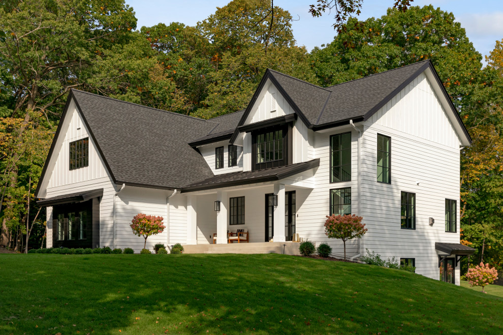Источник вдохновения для домашнего уюта: двухэтажный, белый частный загородный дом с комбинированной облицовкой, черной крышей и крышей из смешанных материалов