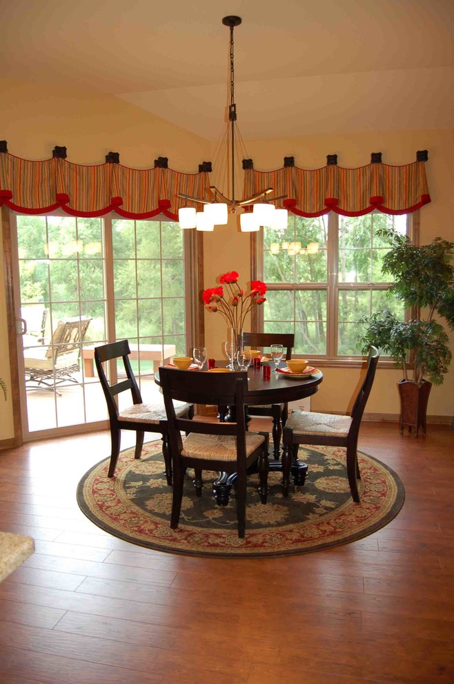 This is an example of a mid-sized traditional open plan dining in Milwaukee with yellow walls and medium hardwood floors.