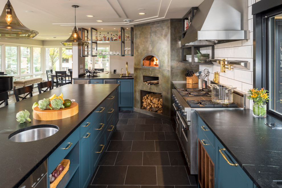 Klassische Küche mit blauen Schränken, Speckstein-Arbeitsplatte, Küchengeräten aus Edelstahl, Kücheninsel und schwarzer Arbeitsplatte in Minneapolis