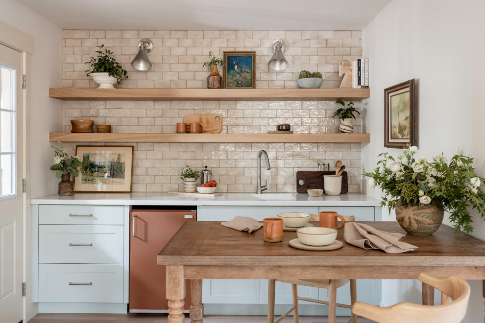 This is an example of a small single-wall kitchen/diner in Sacramento with a submerged sink, shaker cabinets, blue cabinets, engineered stone countertops, beige splashback, ceramic splashback, coloured appliances, no island and white worktops.