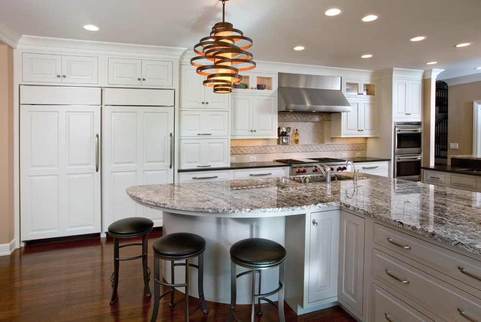 This is an example of a traditional kitchen in Cincinnati with an undermount sink, raised-panel cabinets, white cabinets, beige splashback and stainless steel appliances.