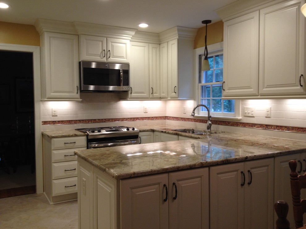 Mid-sized transitional u-shaped ceramic tile eat-in kitchen photo in Richmond with an undermount sink, raised-panel cabinets, white cabinets, granite countertops, white backsplash, subway tile backsplash, stainless steel appliances and a peninsula