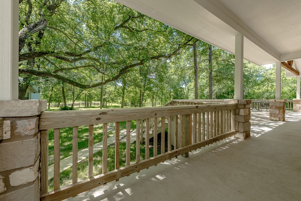 Mid-sized transitional backyard concrete deck photo in Austin with a roof extension