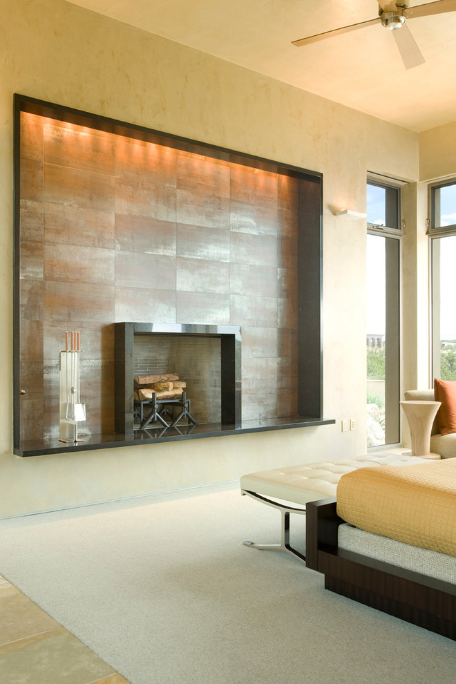 Photo of a contemporary bedroom in Albuquerque with beige walls, carpet, a standard fireplace and a tile fireplace surround.