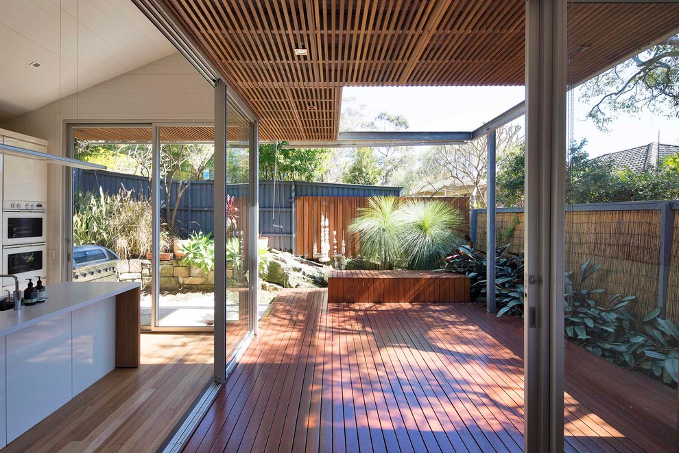 Photo of a small beach style backyard deck in Sydney with a roof extension.