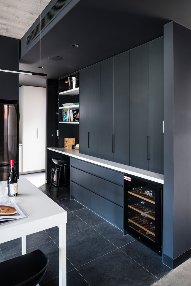 Design ideas for a large modern l-shaped open plan kitchen in Melbourne with an undermount sink, flat-panel cabinets, black cabinets, quartz benchtops, white splashback, glass sheet splashback, stainless steel appliances, porcelain floors, with island, grey floor and white benchtop.