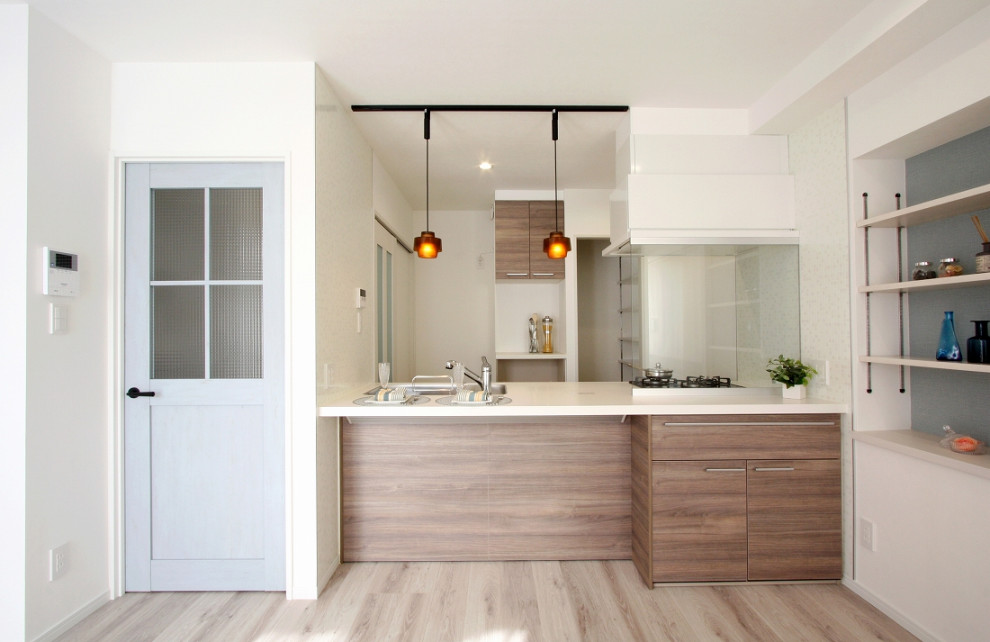 Photo of a mid-sized modern single-wall open plan kitchen in Other with light hardwood floors, beige floor, wallpaper, dark wood cabinets and solid surface benchtops.