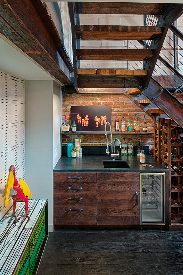 Inspiration for a small industrial wine cellar in New York with dark hardwood floors, storage racks and brown floor.