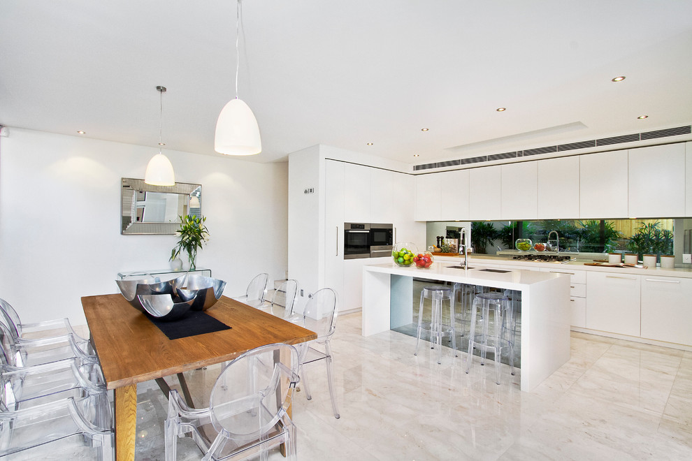 Photo of a mid-sized contemporary eat-in kitchen in Sydney with flat-panel cabinets, white cabinets, stainless steel appliances, with island, an undermount sink, quartz benchtops and travertine floors.